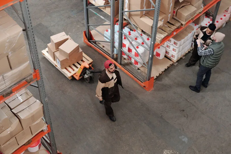 Entrepôt de préparation de commandes, palettes et cartons sur transpalette